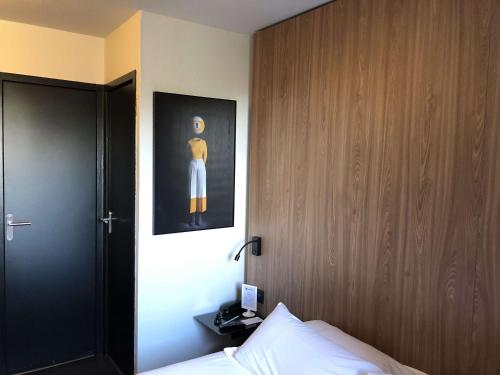 a bedroom with a bed with a picture on the wall at Best Western Bridge Hotel Lyon East in Jons