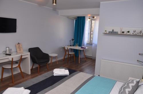 a room with a bed and a table and chairs at Aparthotel Danube in Galaţi