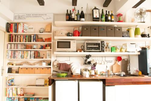 a kitchen with a counter and a microwave and books at May Rooms Taipei Main Station in Taipei