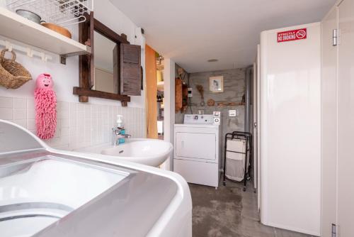 a bathroom with a sink and a tub and a kitchen at May Rooms Taipei Main Station in Taipei