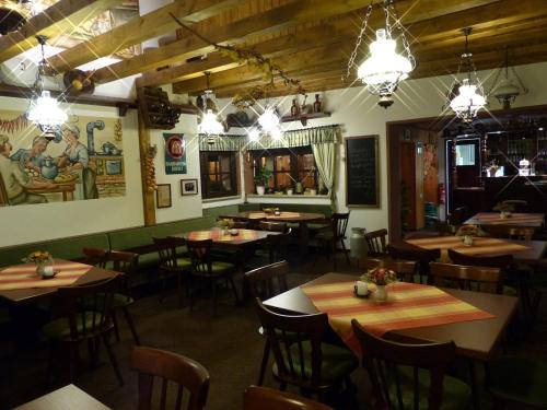 a restaurant with wooden tables and chairs and lights at Hotel Friedchen mit eigener Fleischerei in Artern