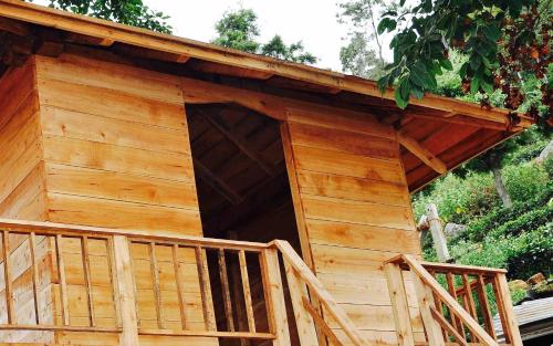 a log cabin with a wooden porch and a balcony at Maruti Villa in Kodaikānāl