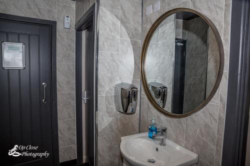 a bathroom with a sink and a mirror at The Farmers Boy Inn Guest House in Longhope