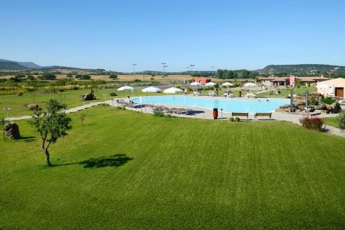 an overhead view of a large green field with a swimming pool at Hotel Sa Cheya Relais & Spa in Alghero