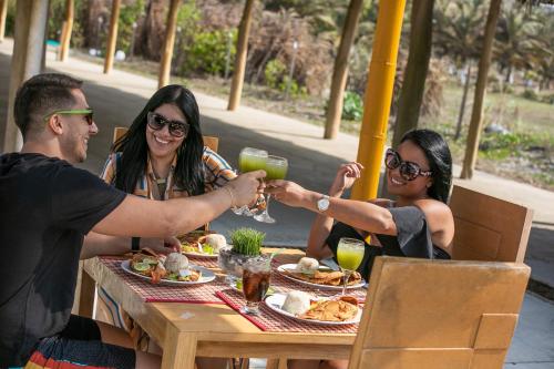 a group of three people sitting around a table with drinks at Hotel Arena Beach Cartagena in Cartagena de Indias