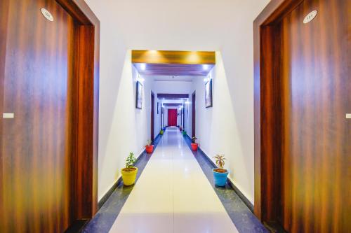 a long corridor with wooden doors and potted plants at FabHotel Pentagon Next - Bhubaneswar Railway Station in Bhubaneshwar
