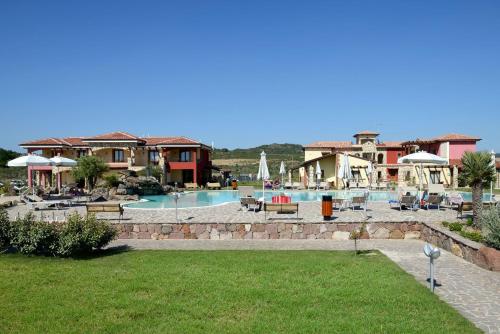 a resort with a swimming pool and some buildings at Hotel Sa Cheya Relais & Spa in Alghero