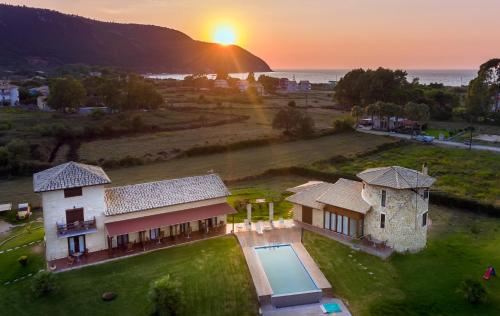 uma vista aérea de uma casa com o pôr-do-sol ao fundo em Ageras Santa Marina em Lefkada