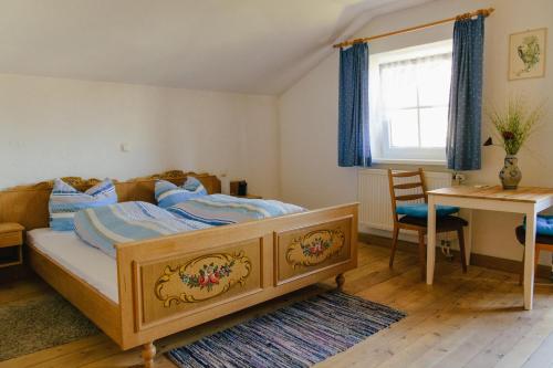 a bedroom with a bed and a table and a desk at Pension Lex in Bad Reichenhall