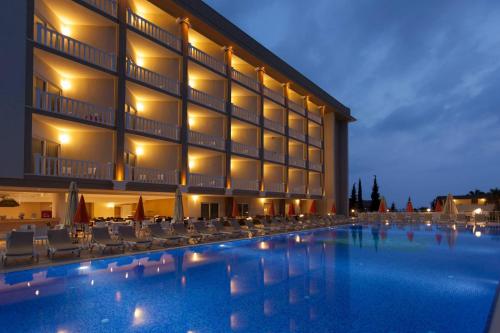 オクルカラールにあるJustiniano Theodora Resortの建物の前にスイミングプールがあるホテル