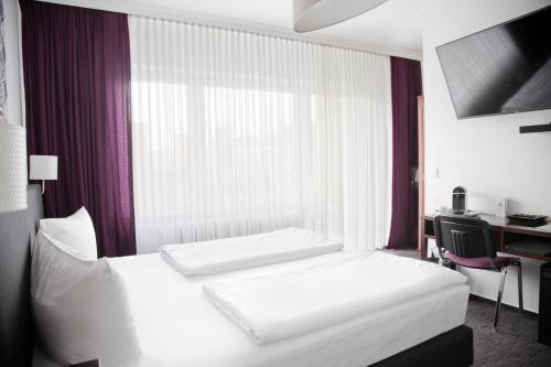 a hotel room with two beds and a desk at Les Nations in Berlin