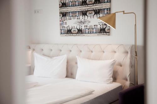 a bedroom with a white bed with pillows at Les Nations in Berlin