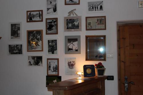 a wall with pictures and a clock on a wall at Villa Ortensia in San Vigilio Di Marebbe