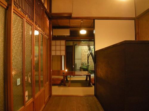 un pasillo con una habitación con una mesa. en Guesthouse Itoya Kyoto, en Kioto