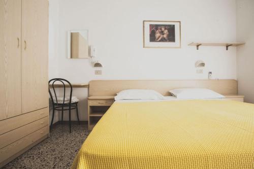 a bedroom with a yellow bed and a chair at Hotel Diana in Misano Adriatico