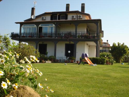a large house with a balcony and a yard at La Mia Casa per Tutti in Cerveteri