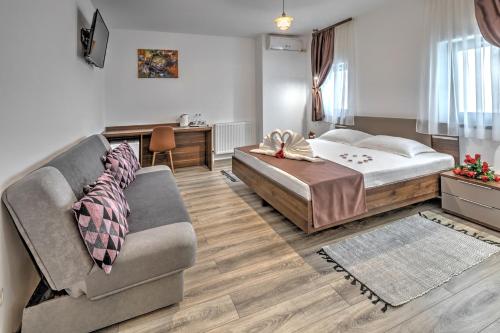 - un salon avec un lit et un canapé dans l'établissement Pensiune Pavo, à Piteşti