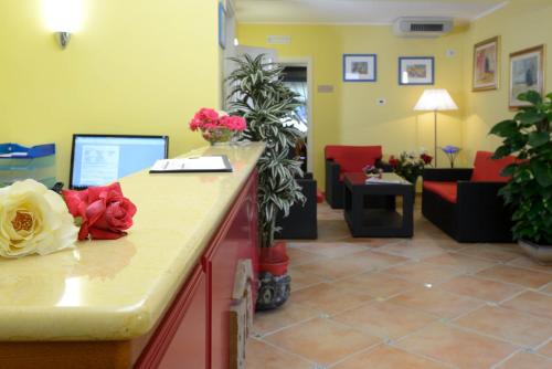 a waiting room with a counter with flowers on it at Hotel Sa Cheya Relais & Spa in Alghero