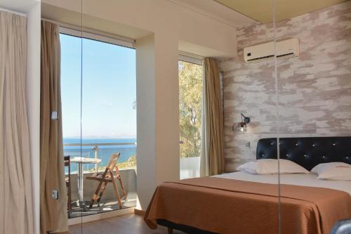 a bedroom with a bed and a large glass window at Scorpios Sea Side Hotel in Piraeus
