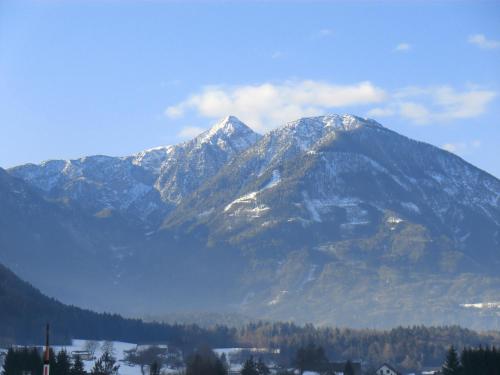 a snow covered mountain range with a town in the foreground at Appartement Landhaus Felsenkeller in Sankt Kanzian