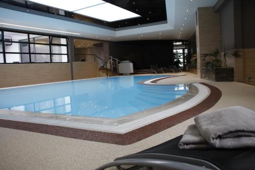 a large swimming pool in a large building at Hôtel Restaurant Les Alizés in Lipsheim