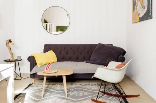 ein Wohnzimmer mit einem Sofa und einem Spiegel in der Unterkunft Nuits étoilées Lourmarin in Lourmarin