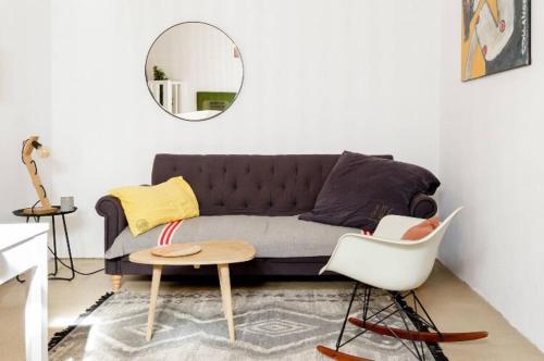 a living room with a couch and a mirror at Nuits étoilées Lourmarin in Lourmarin