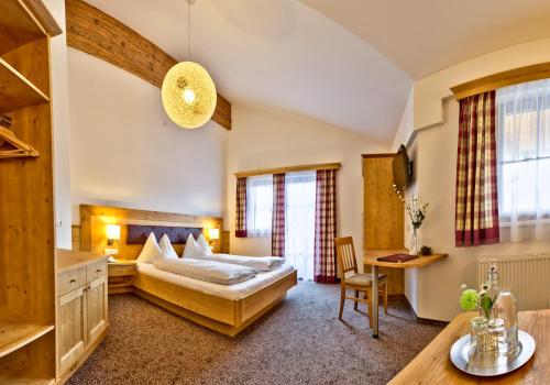 Habitación de hotel con cama y escritorio en Hotel Salzburgerhof, en Flachau