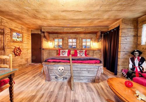 Cette chambre comprend un lit dans une cabane en rondins. dans l'établissement Mas Le Colombier, à Bompas