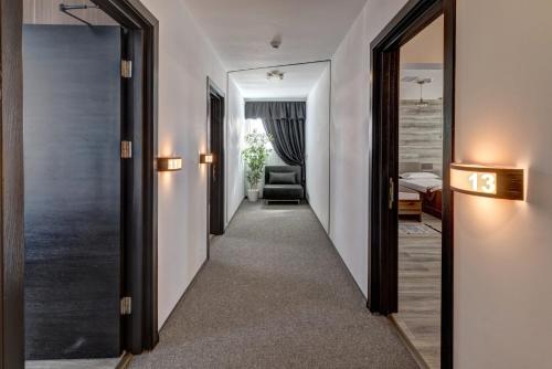 a hallway with a mirror and a room with a bed at Pensiune Pavo in Piteşti
