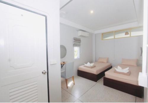 a small room with two beds and a mirror at Ler Hostel 65 in Chaweng