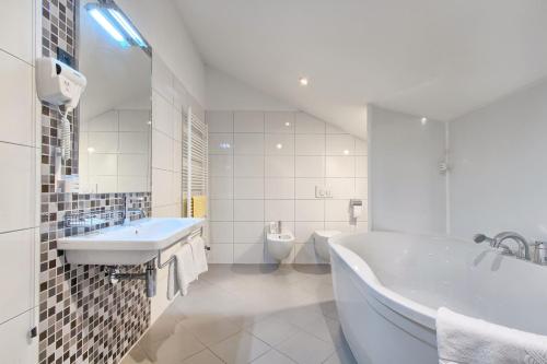 ein weißes Bad mit einer Badewanne und einem WC in der Unterkunft Hotel Galija in Pula