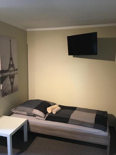 a bedroom with a bed with a tv on the wall at Die Kantine Wittenburg Zimmervermietung und Hostel in Wittenburg