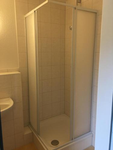 a shower with a glass door in a bathroom at Die Kantine Wittenburg Zimmervermietung und Hostel in Wittenburg