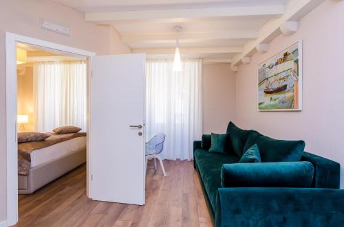 a living room with a green couch and a bed at Villa Flores in Dubrovnik