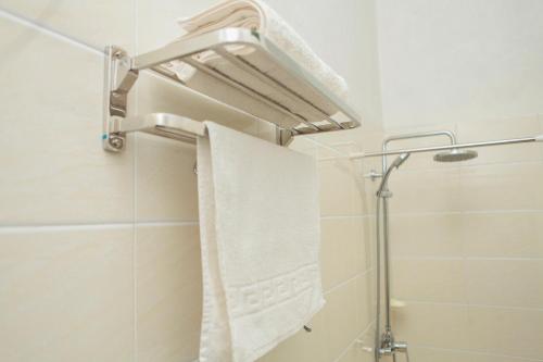 a bathroom with a shower with a white towel at Hotel Kangaroo Bujumbura in Bujumbura