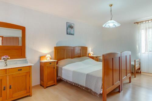 a bedroom with a bed and a sink and a mirror at Armida in Veli Lošinj