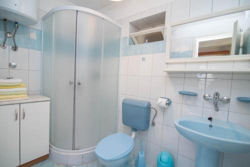 a bathroom with a blue toilet and a sink at Roberto 2 in Veli Lošinj