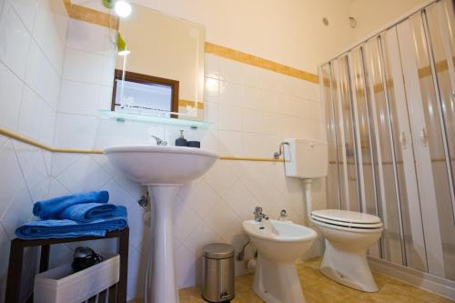 a white bathroom with a sink and a toilet at Experience Il Paesino in Licodia Eubea