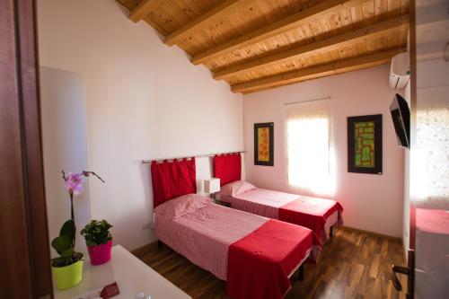een slaapkamer met 2 bedden in een kamer met houten plafonds bij Experience Il Paesino in Licodia Eubea