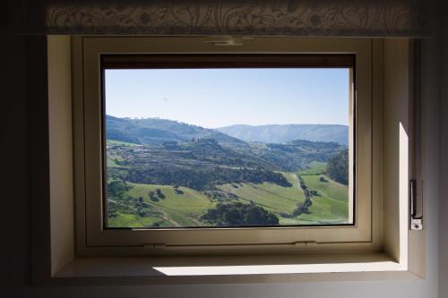 a window with a view of a green valley at Experience Il Paesino in Licodia Eubea