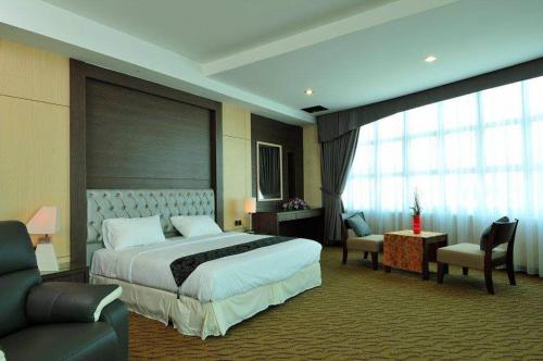 a hotel room with a large bed and a couch at Hotel Pen Mutiara in Kampong Batu Maung