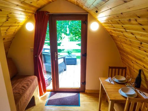 Cette petite chambre dispose d'une table et d'une porte donnant sur une terrasse. dans l'établissement Colemans Cottage Fishery, à Wickham Bishops
