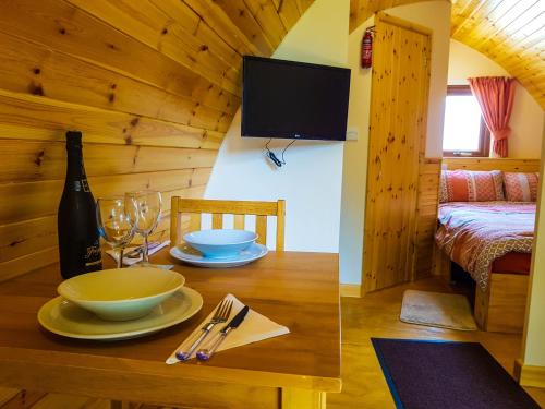 a wooden room with a table with a bottle of wine at Colemans Cottage Fishery in Wickham Bishops