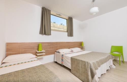 a bedroom with two beds and a window at Villetta Pistacchio & Ribes in Marina di Pescoluse