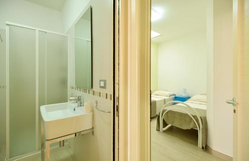 a bathroom with a sink and a bed in a room at Villetta Pistacchio & Ribes in Marina di Pescoluse