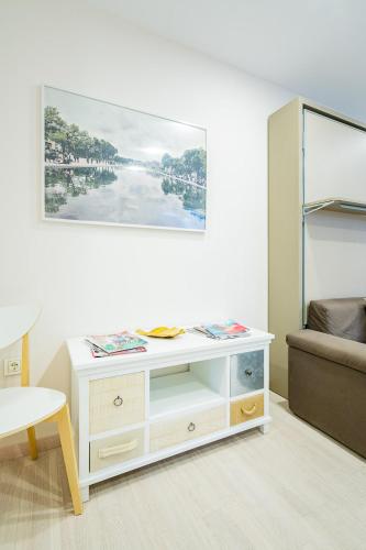 a white dresser in a room with a painting on the wall at Exclusive quietness in the heart of Madrid with Public Parking, Breakfast, 2 bathrooms in Madrid