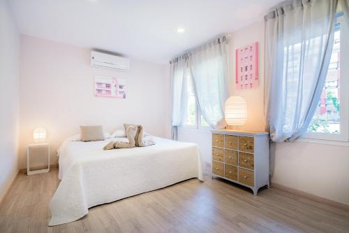 a white bedroom with two beds and a window at Exclusive quietness in the heart of Madrid with Public Parking, Breakfast, 2 bathrooms in Madrid