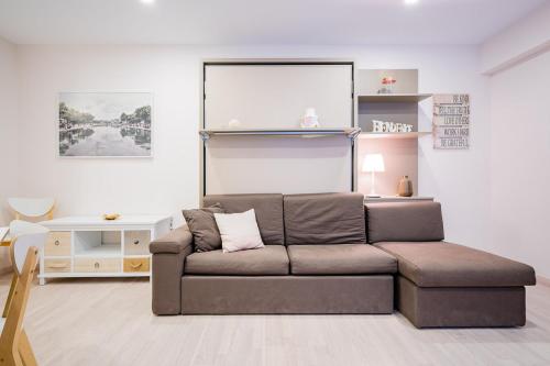 a living room with a brown couch in a room at Exclusive quietness in the heart of Madrid with Public Parking, Breakfast, 2 bathrooms in Madrid