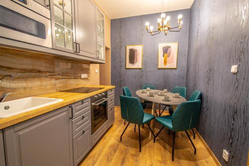 een keuken met een tafel en stoelen en een wastafel bij Ruterra Apartments by Cathedral in Praag